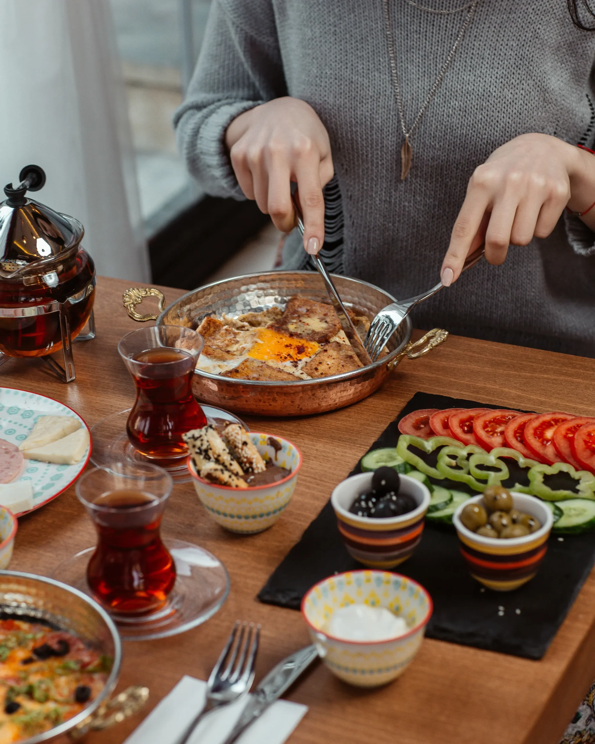 woman-eating-breakfast-omlette-with-black-tea-foods-around